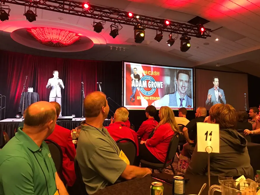 The Adam Growe Quiz Show live in a ballroom, with the audience facing the stage screens
